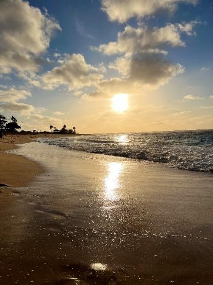 A beach with water and clouds

Description automatically generated